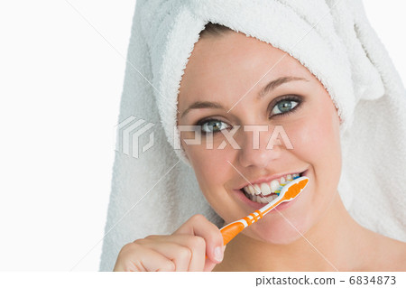 Woman with hair towel washing her teeth 6834873