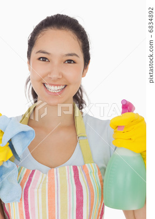 Happy woman holding spray bottle and rag 6834892