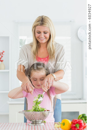 Woman and child mixing salad together Woman and child mixing salad together 6834927