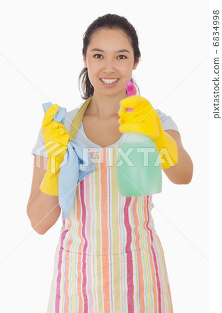 Smiling woman holding out spray bottle 6834998
