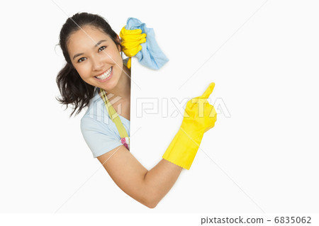 Woman in rubber gloves pointing to the white surface 6835062