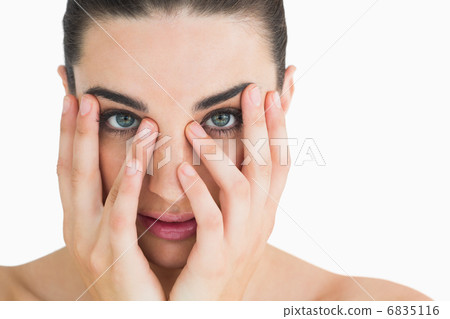 Pale woman touching her face 6835116