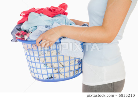 Woman holding a basket overflowing of laundry Woman holding a basket overflowing of laundry 6835210