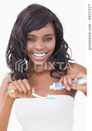 Woman holding a toothbrush while smiling 6835327