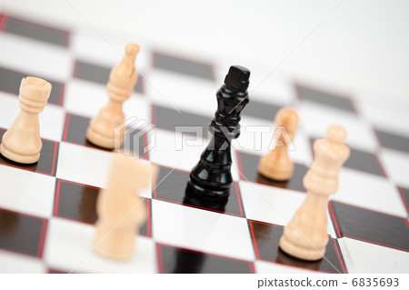 Black queen surrounded by white chess pieces 6835693