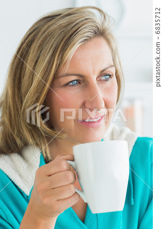 Thoughtful woman sitting in the kitchen Thoughtful woman sitting in the kitchen 6835712