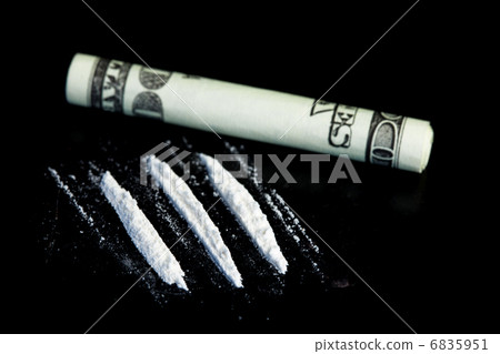 Lines of illegal substance next to rolled up dollar bill 6835951