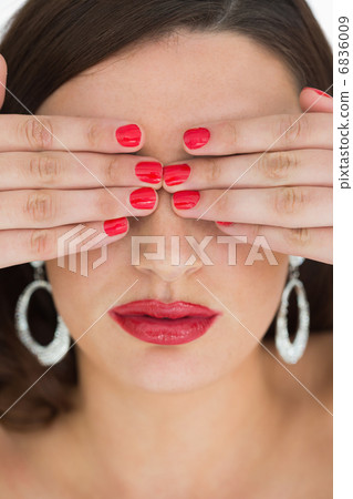 Woman hiding her eyes while wearing red Woman hiding her eyes while wearing red 6836009