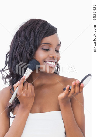 Woman putting on face powder Woman putting on face powder 6836436