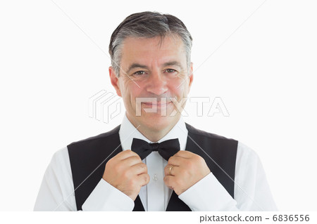 Waiter adjusting his own bow tie 6836556