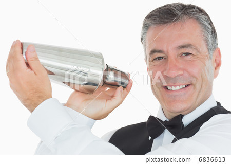 Happy waiter shaking drink in cocktail shaker 6836613