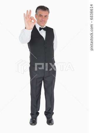 Smiling waiter showing ok sign 6836614
