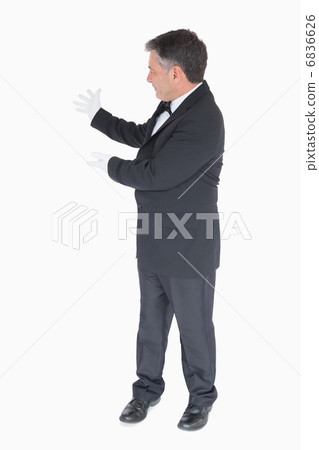 Waiter showing something to the left 6836626