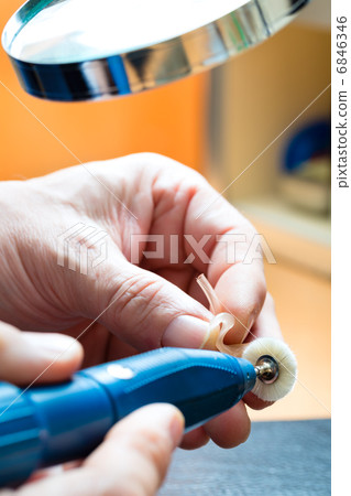 Acoustician working on a hearing aid 6846346