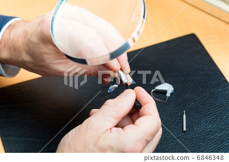 Acoustician working on a hearing aid 6846348