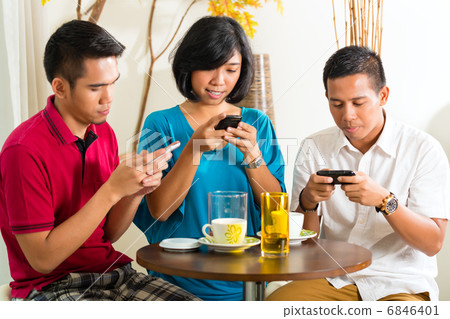 Asian people having fun with mobile phone 6846401