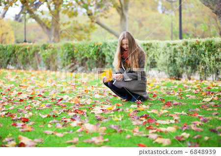 Girl with long hair gathering autumn leaves 6848939