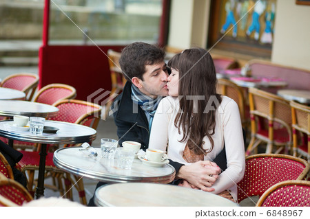 Young couple kissing in an outdoor cafe 6848967