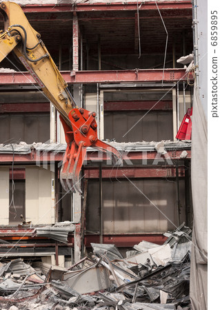 Dismantling work of the building by heavy machinery Dismantling work of the building by heavy machinery 6859895