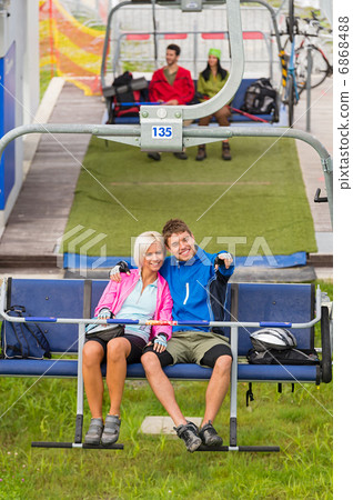 Cuddling couple pointing chair lift in sweatsuits Cuddling couple pointing chair lift in sweatsuits 6868488