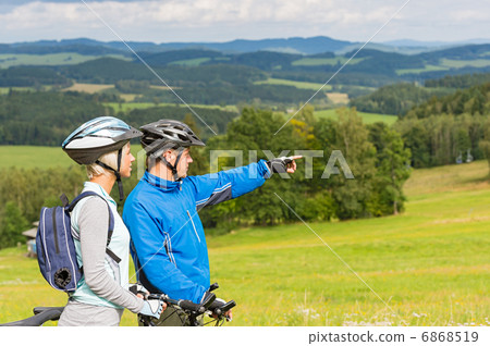 Pointing cyclists couple on summer weekend nature 6868519