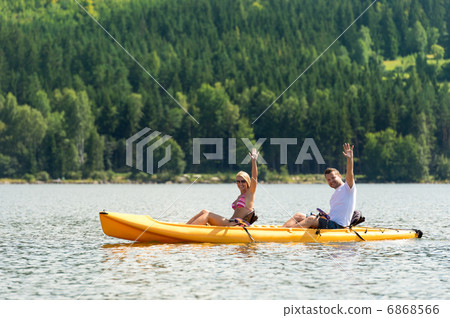 Man and woman kayaking on pond vacation Man and woman kayaking on pond vacation 6868566