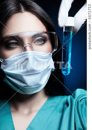 scientist holding tube with blue liquid inside scientist holding tube with blue liquid inside 6872753