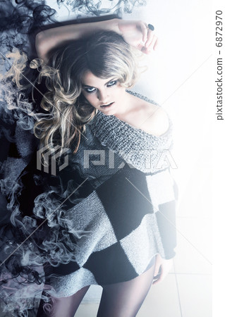 blonde woman in sweater with smoke 6872970