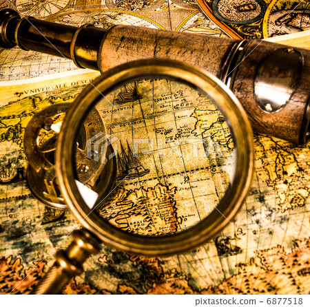 Vintage magnifying glass lies on an ancient world map 6877518