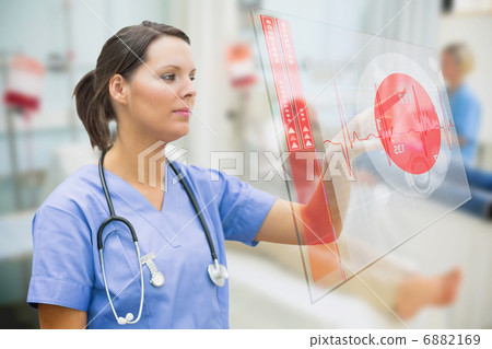 Nurse touching screen showing red ECG data 6882169