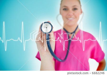 Nurse holding up stethoscope to ECG line Nurse holding up stethoscope to ECG line 6882246