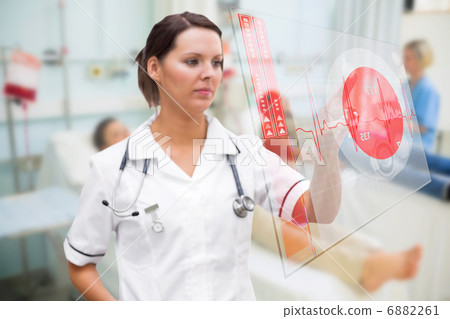 Nurse pressing screen showing red ECG data 6882261
