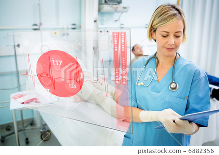 Nurse consulting tablet with screen displaying ECG in foreground 6882356