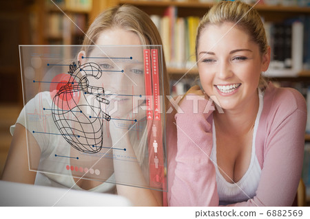 Friends sitting in library with laptop Friends sitting in library with laptop 6882569