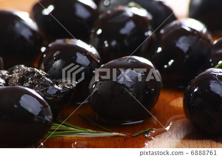 Black olives on a wooden table. 6888761