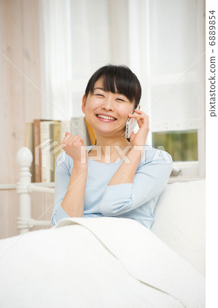 在床上享受智能手機的女人 在床上享受智能手機的女人 6889854