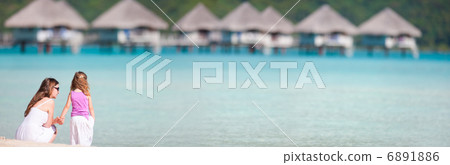 Mother and daughter at resort beach 6891886