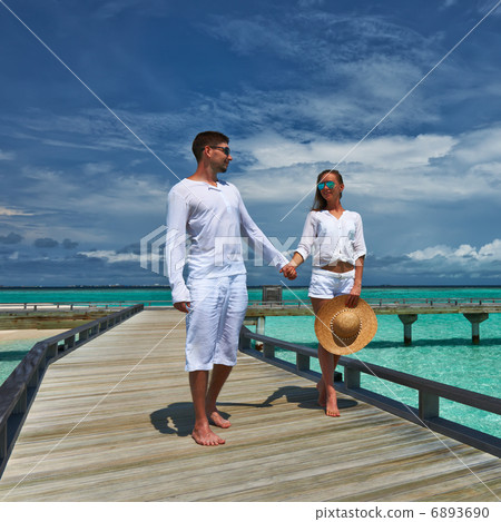 Couple on a beach jetty at Maldives Couple on a beach jetty at Maldives 6893690