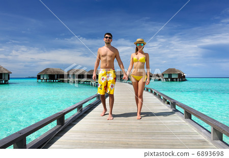 Couple on a beach jetty at Maldives Couple on a beach jetty at Maldives 6893698