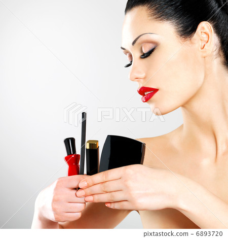 Woman with makeup cosmetic tools near her face. Woman with makeup cosmetic tools near her face. 6893720