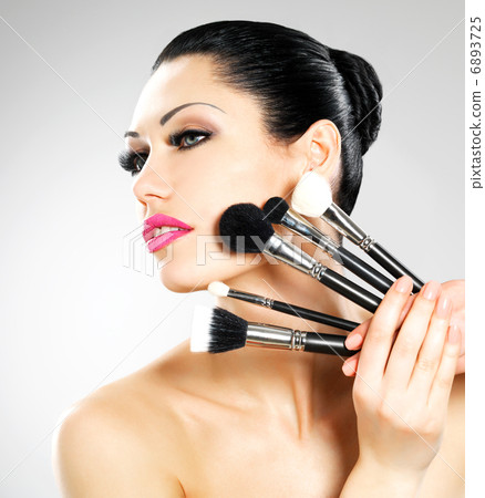 Beautiful woman with makeup brushes Beautiful woman with makeup brushes 6893725