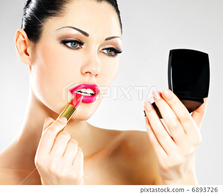 Beautiful woman applying pink lipstick on lips Beautiful woman applying pink lipstick on lips 6893726