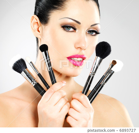 Beautiful woman with makeup brushes Beautiful woman with makeup brushes 6893727