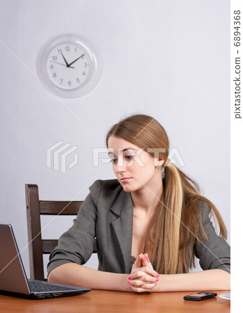 Serious businesswoman working on laptop 6894368