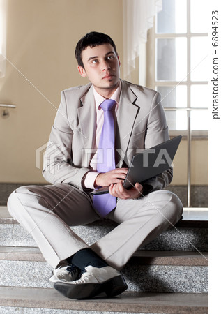 Young businessman sitting on the stairs Young businessman sitting on the stairs 6894523