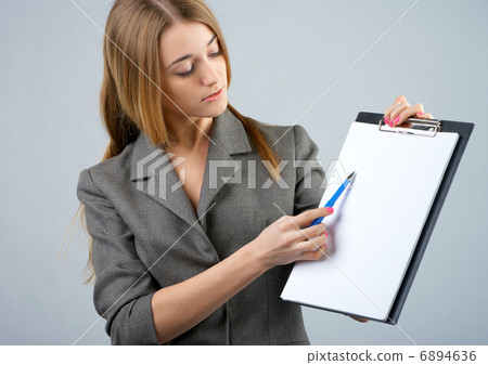 Businesswoman holding a clipboard and showing something Businesswoman holding a clipboard and showing something 6894636