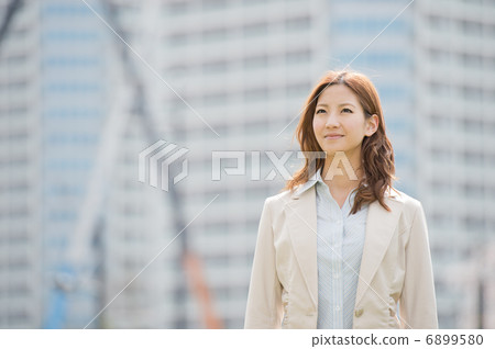 A woman standing in front of an apartment under construction 6899580