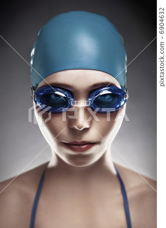 Stylish portrait of a young woman in goggles and swimming cap 6904632