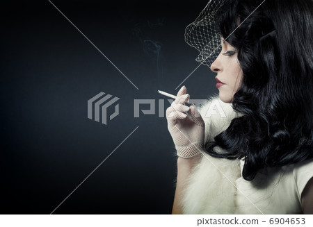 Retro woman smoking on dark background Retro woman smoking on dark background 6904653