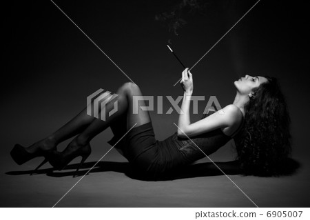 woman smokes in the dark. studio shot. space for text. BW Image woman smokes in the dark. studio shot. space for text. BW Image 6905007